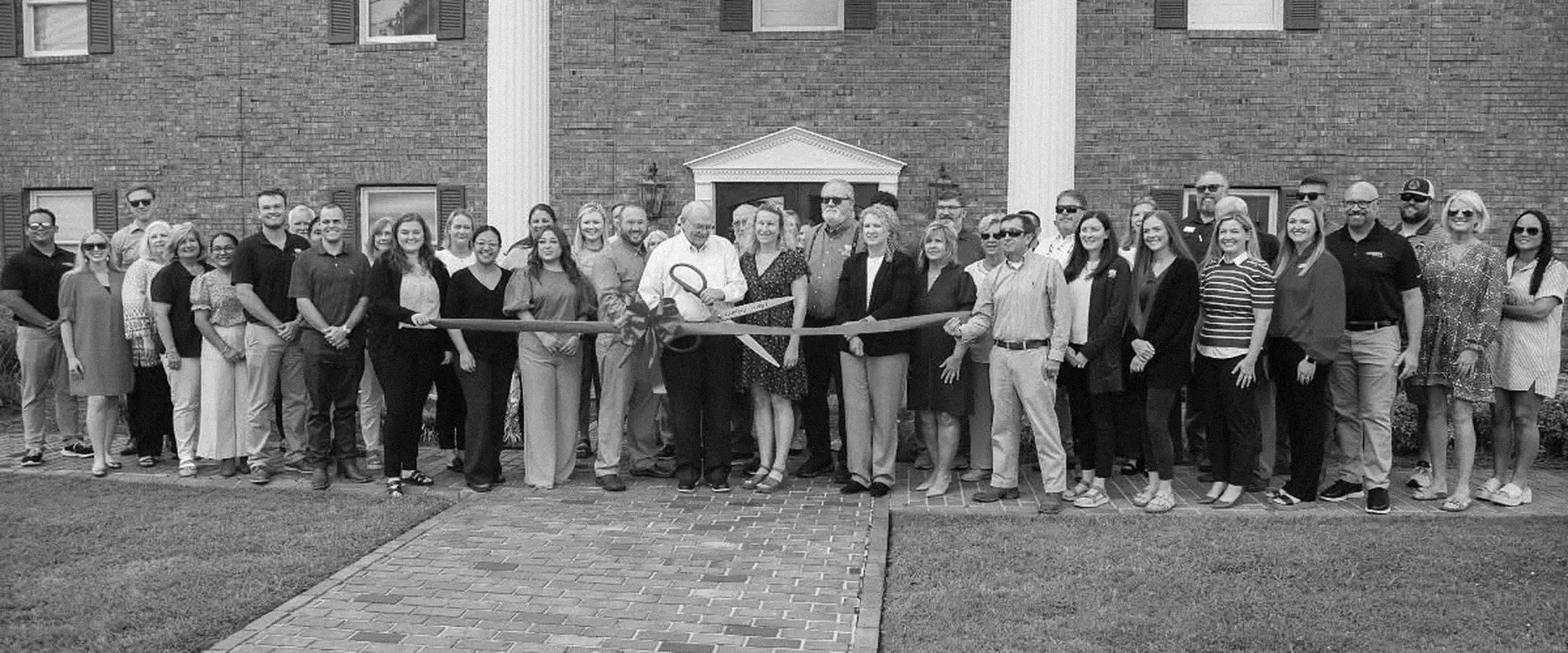 The MDA team at a ribbon cutting in front of the Albertville office